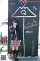 A woman standing in front of a blackboard with writing on it.