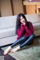 A woman sitting on the floor in a living room.