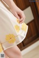 a woman in a white dress with yellow flowers on it