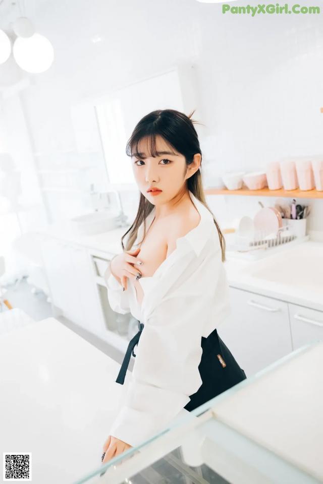 A woman standing in a kitchen next to a counter.