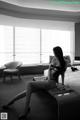 A woman sitting on a bed in a hotel room.