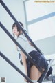 A woman in a school uniform is standing on a stairway.