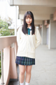 A young woman in a school uniform posing for a picture.