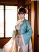 A woman in a blue and white hanfu is posing for a picture.