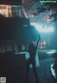 A woman standing in the middle of a street at night.